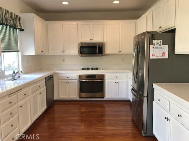 a kitchen with white cabinets and stainless steel appliances