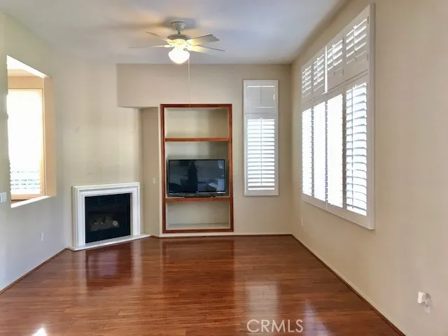 a view of an empty room with a window and fireplace