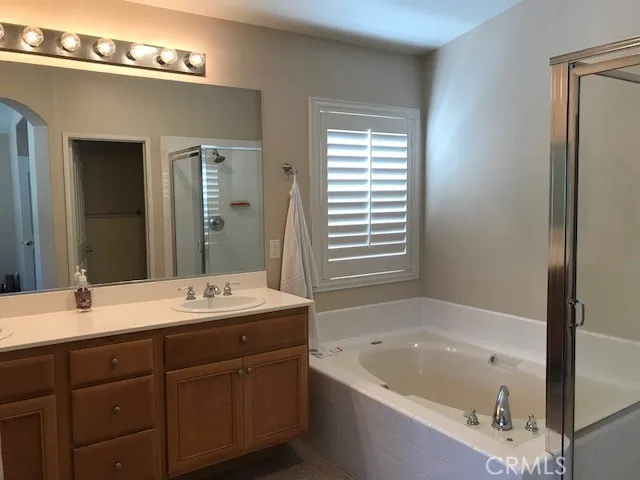 a bathroom with a tub a sink and mirror