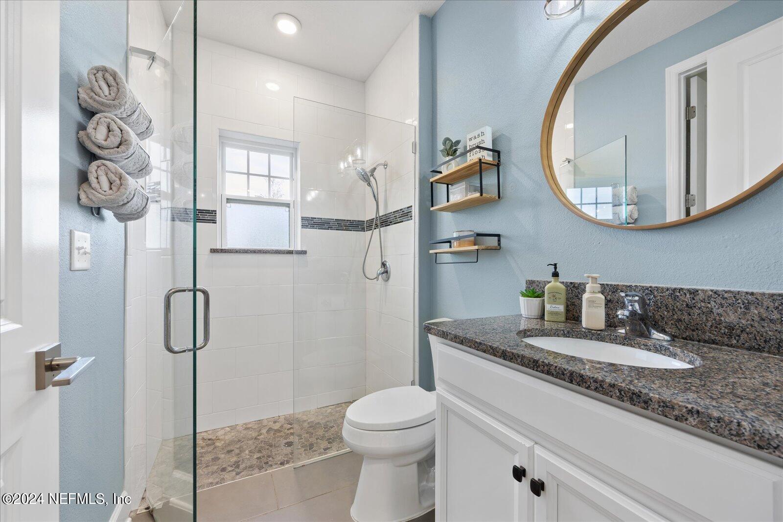196 Ashbury Street St. Augustine, FL 32092 - Photo 12 of 35 a bathroom with a granite countertop sink a toilet and a mirror