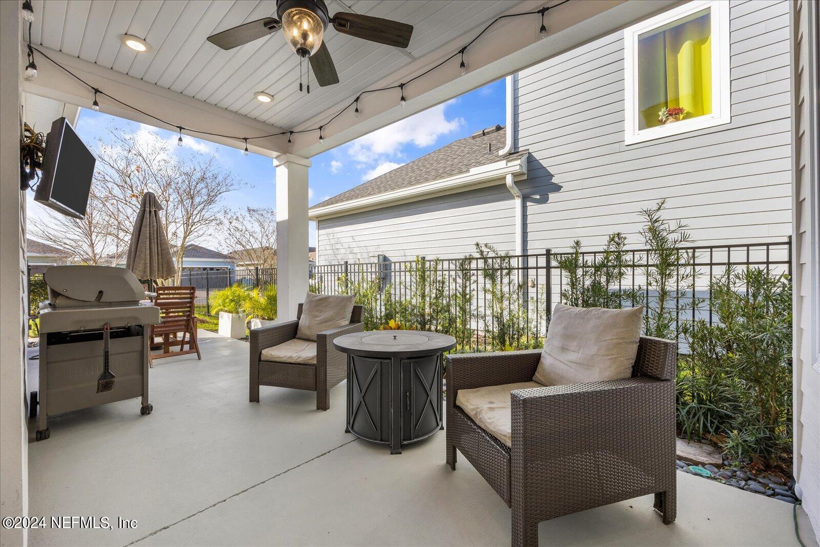 196 Ashbury Street St. Augustine, FL 32092 - Photo 20 of 35 a living room with patio furniture and a floor to ceiling window