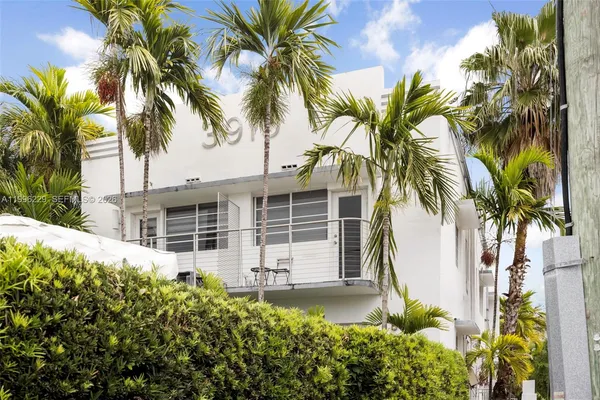 a view of a house with a yard and palm trees