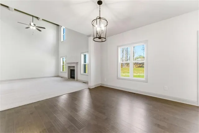 a large kitchen with stainless steel appliances kitchen island granite countertop a stove a refrigerator a sink a dishwasher and white cabinets with wooden floor