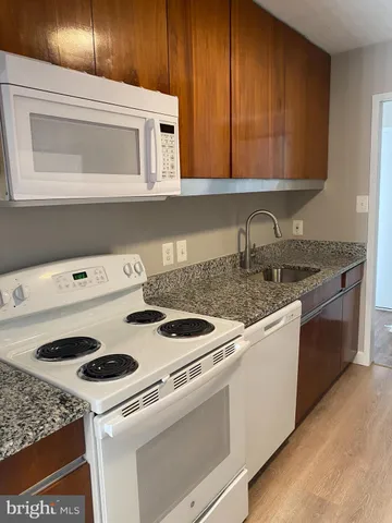 a kitchen with granite countertop a stove and a refrigerator