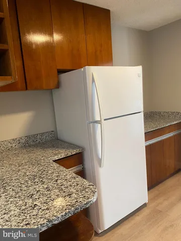 a kitchen with granite countertop cabinets and white appliances