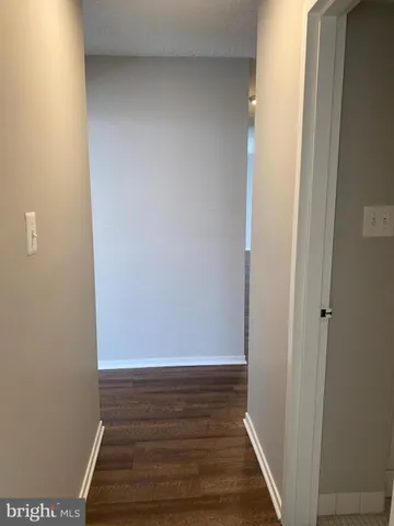 a view of an empty room with hallway and stairs