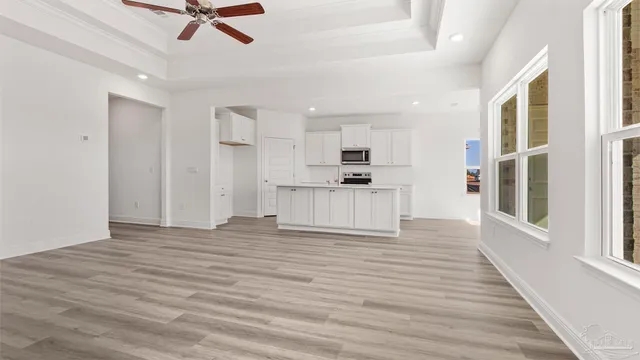 a view of a kitchen with wooden floor and electronic appliances