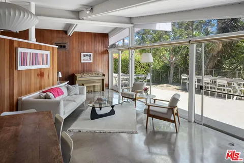 a living room with furniture and a floor to ceiling window