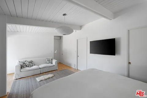 a bedroom with a bed and a large window with garden view