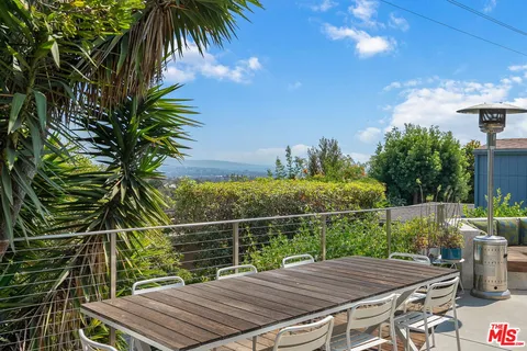 a view of a balcony with chairs and a potted plant