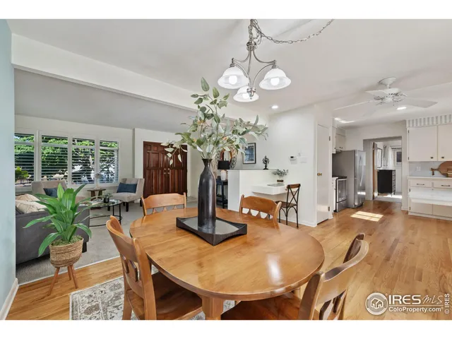 a dining room with wooden floor a chandelier a wooden table and chairs