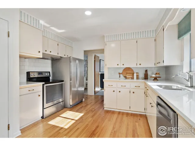 a kitchen with white cabinets stainless steel appliances and sink