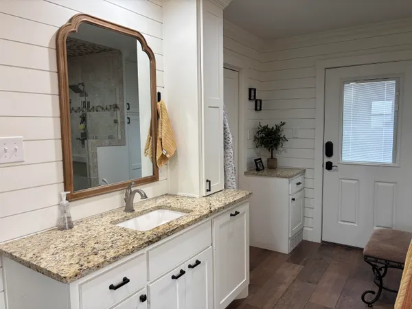 a bathroom with a granite countertop toilet sink and mirror