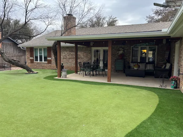 a view of a backyard with table and chairs and wooden fence