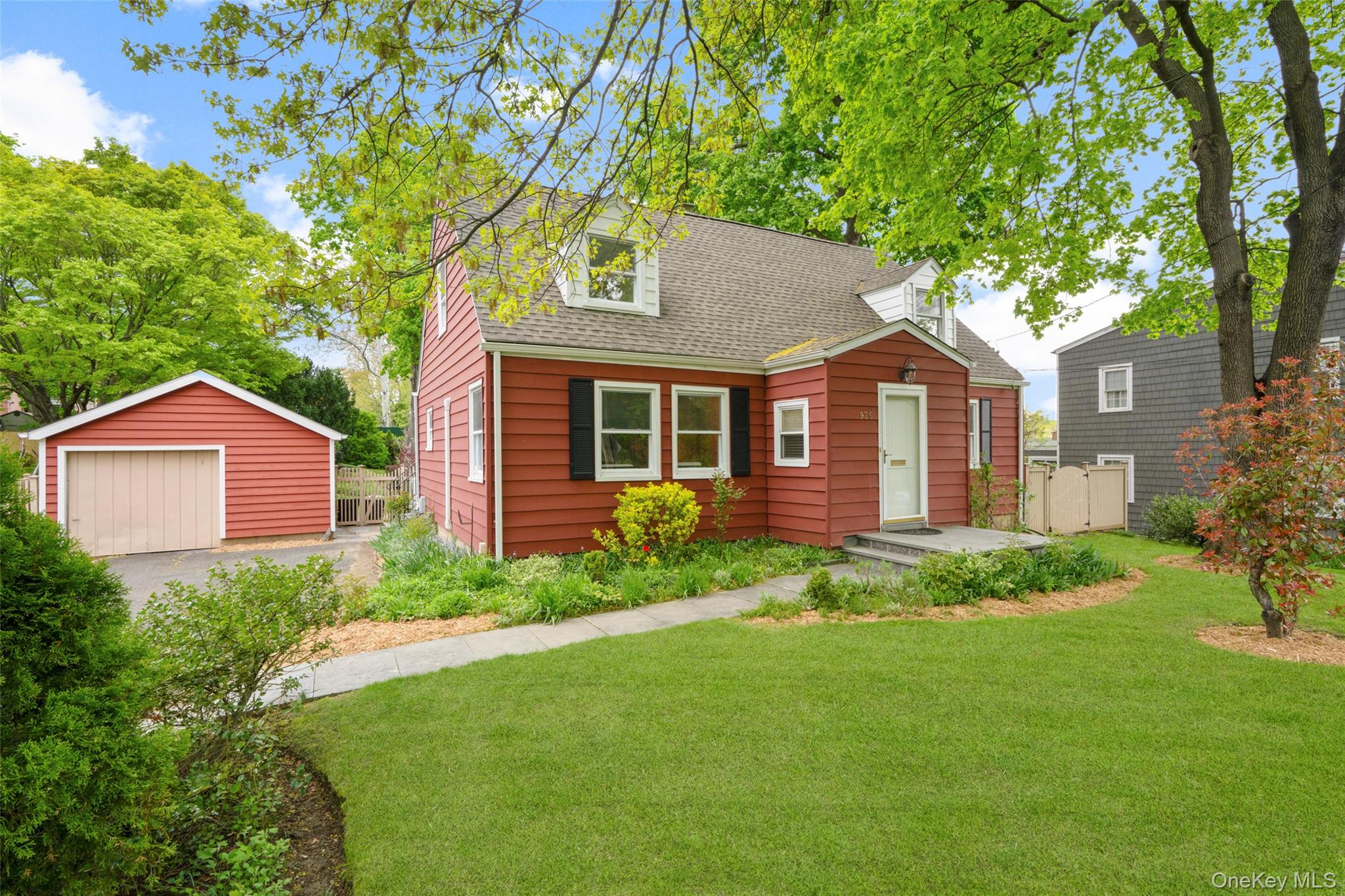 a front view of a house with a yard and trees