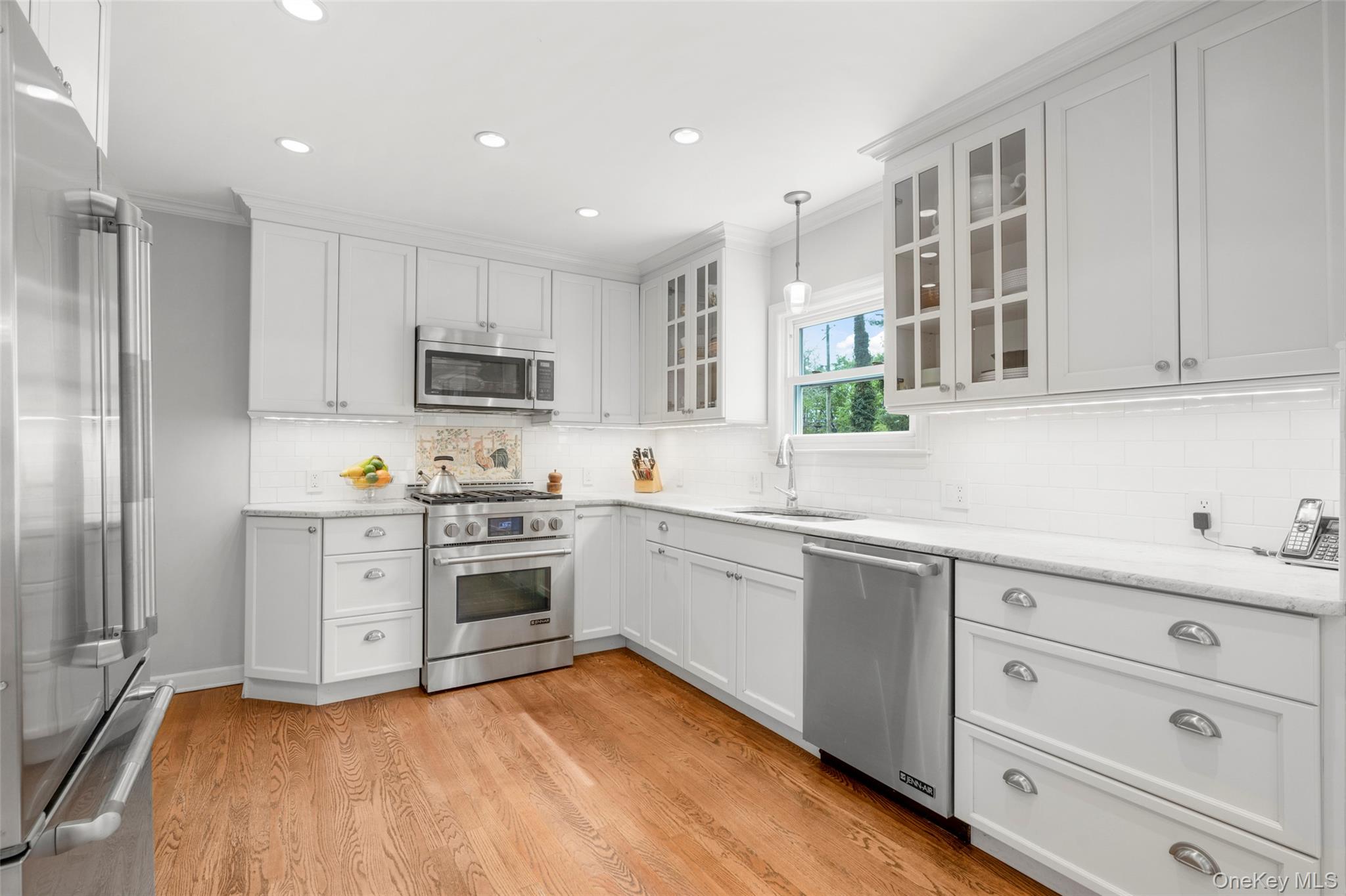 925 Old Boston Post Road Mamaroneck, NY 10543 - Photo 6 of 26 a kitchen with granite countertop white cabinets and stainless steel appliances