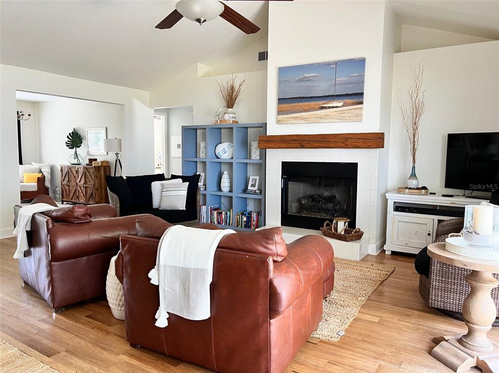 12595 Southeast Sunset Harbor Road Weirsdale, FL 32195 - Photo 8 of 25 a living room with furniture a fireplace and a flat screen tv