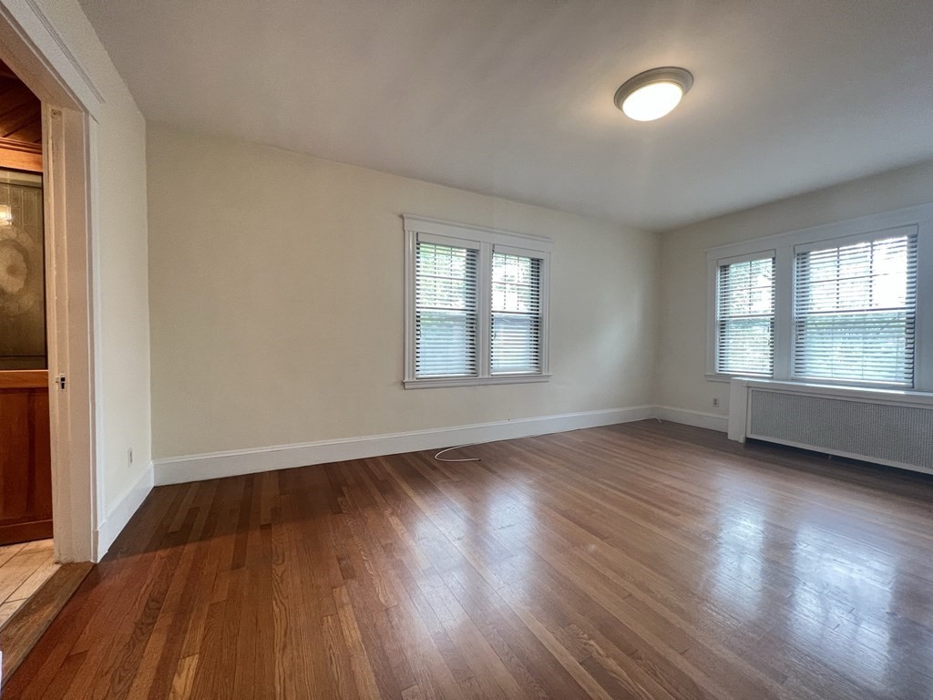 84 Winthrop Road Brookline, MA 02445 - Photo 11 of 42 an empty room with wooden floor and windows