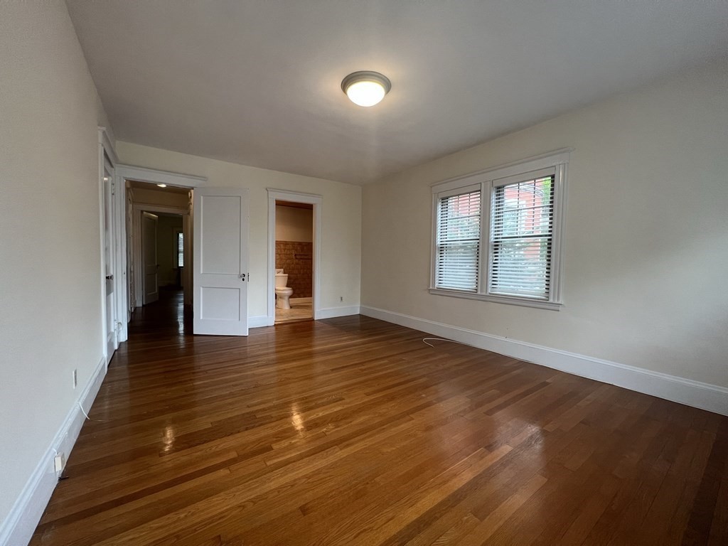 84 Winthrop Road Brookline, MA 02445 - Photo 12 of 42 an empty room with wooden floor and windows