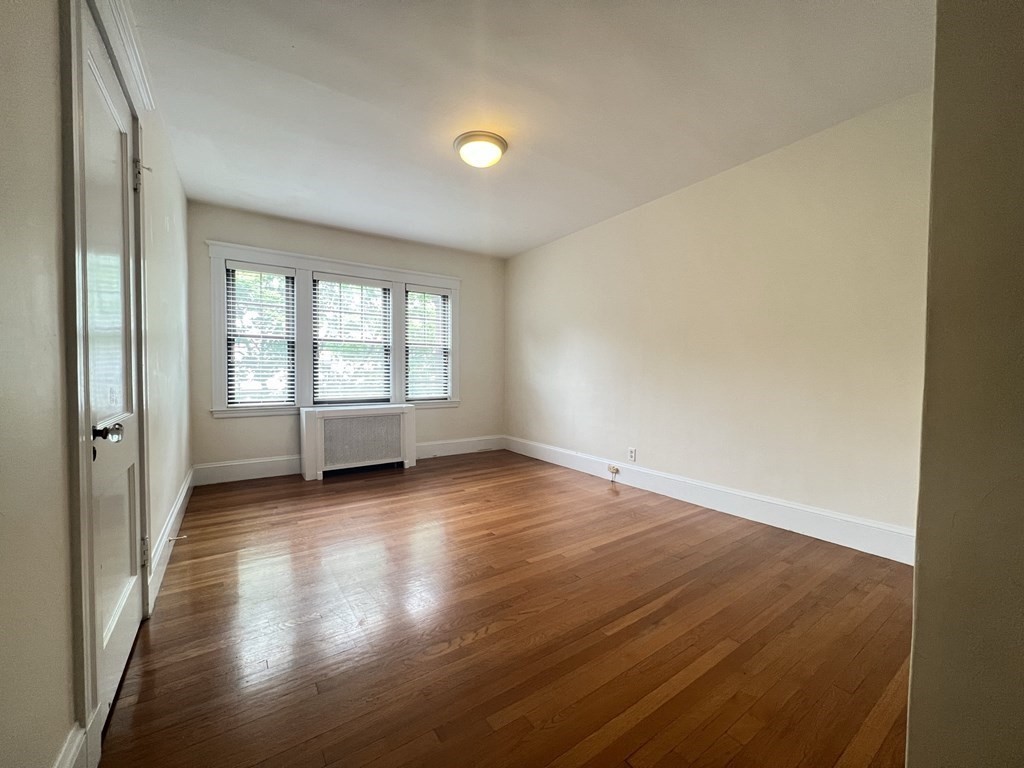 84 Winthrop Road Brookline, MA 02445 - Photo 14 of 42 an empty room with wooden floor and windows