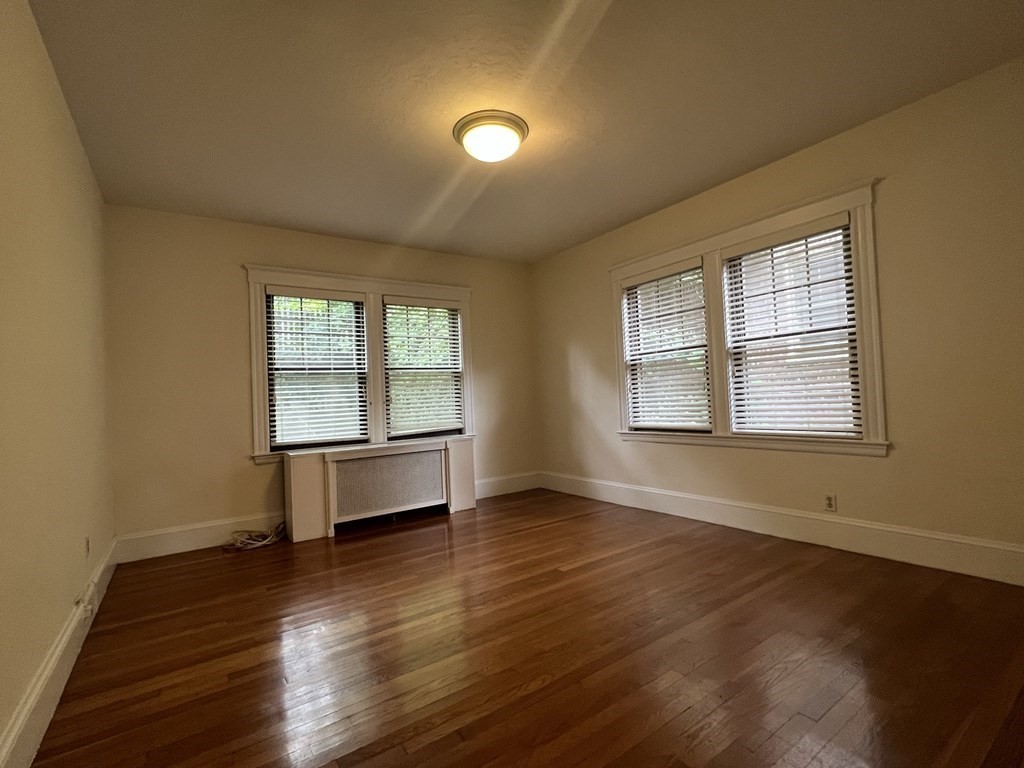 84 Winthrop Road Brookline, MA 02445 - Photo 15 of 42 a view of an empty room with a window and wooden floor