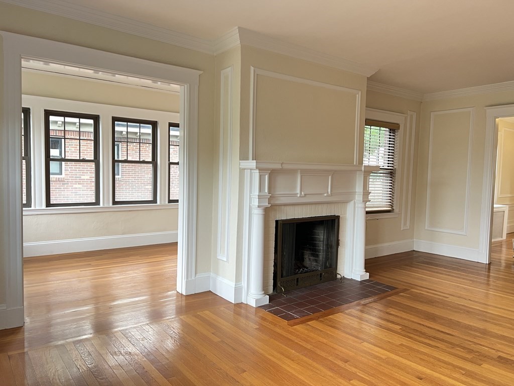 84 Winthrop Road Brookline, MA 02445 - Photo 20 of 42 an empty room with wooden floor fireplace and windows