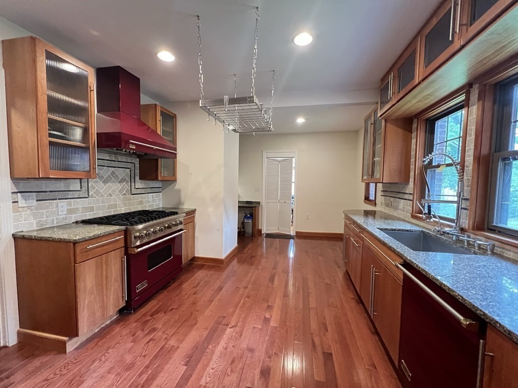 84 Winthrop Road Brookline, MA 02445 - Photo 25 of 42 a kitchen with stainless steel appliances granite countertop wooden floors and wooden cabinets