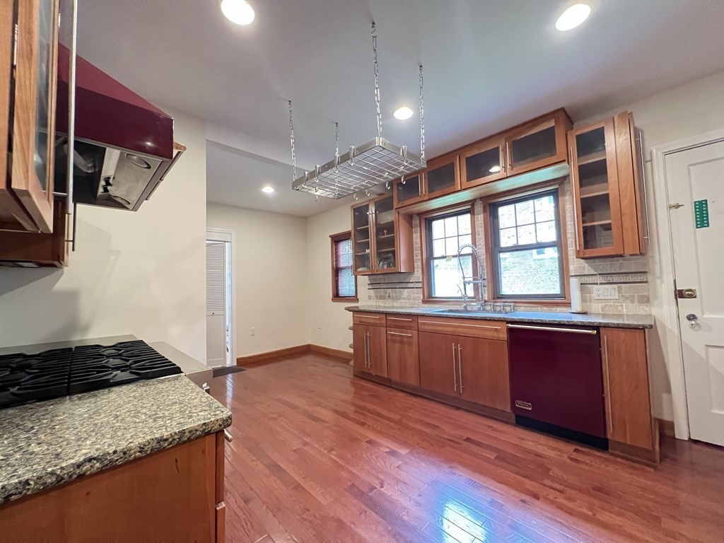 84 Winthrop Road Brookline, MA 02445 - Photo 26 of 42 a kitchen with stainless steel appliances granite countertop wooden cabinets and a stove top oven