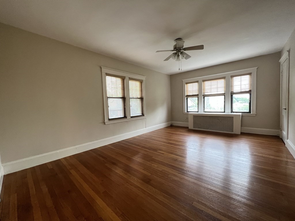84 Winthrop Road Brookline, MA 02445 - Photo 28 of 42 wooden floor in an empty room with a window