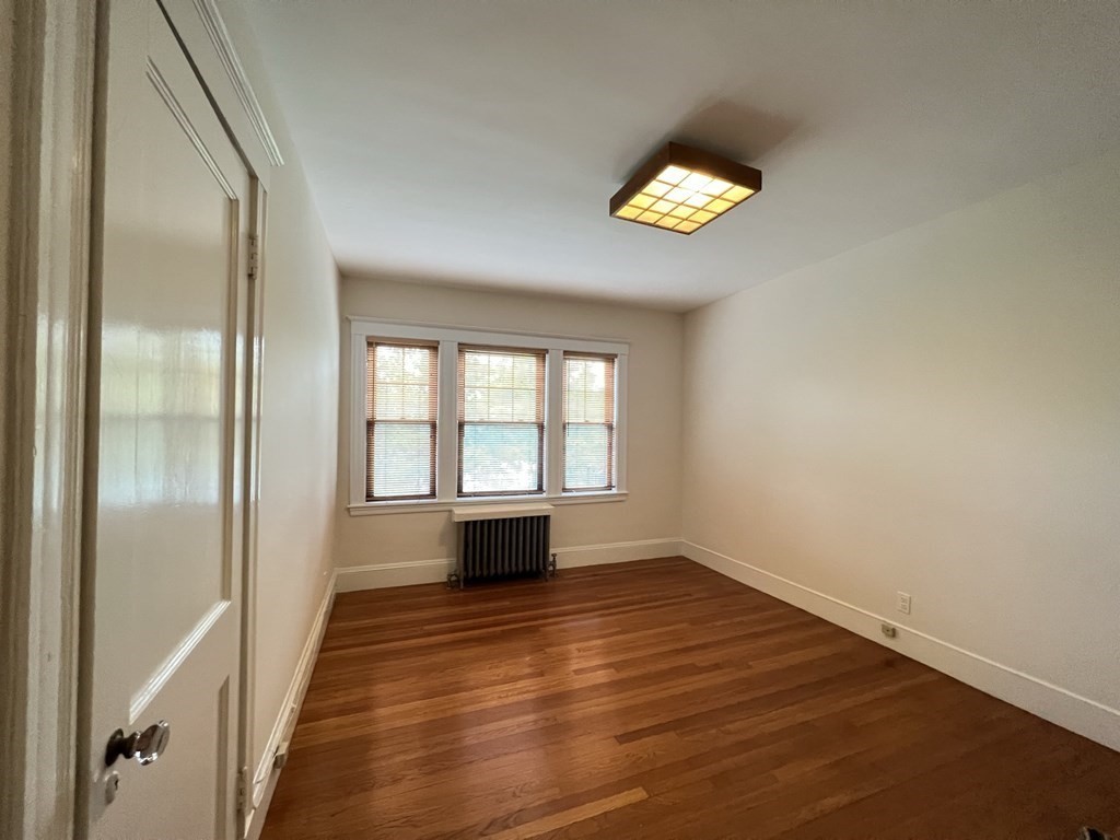 84 Winthrop Road Brookline, MA 02445 - Photo 30 of 42 a view of an empty room with a window and wooden floor