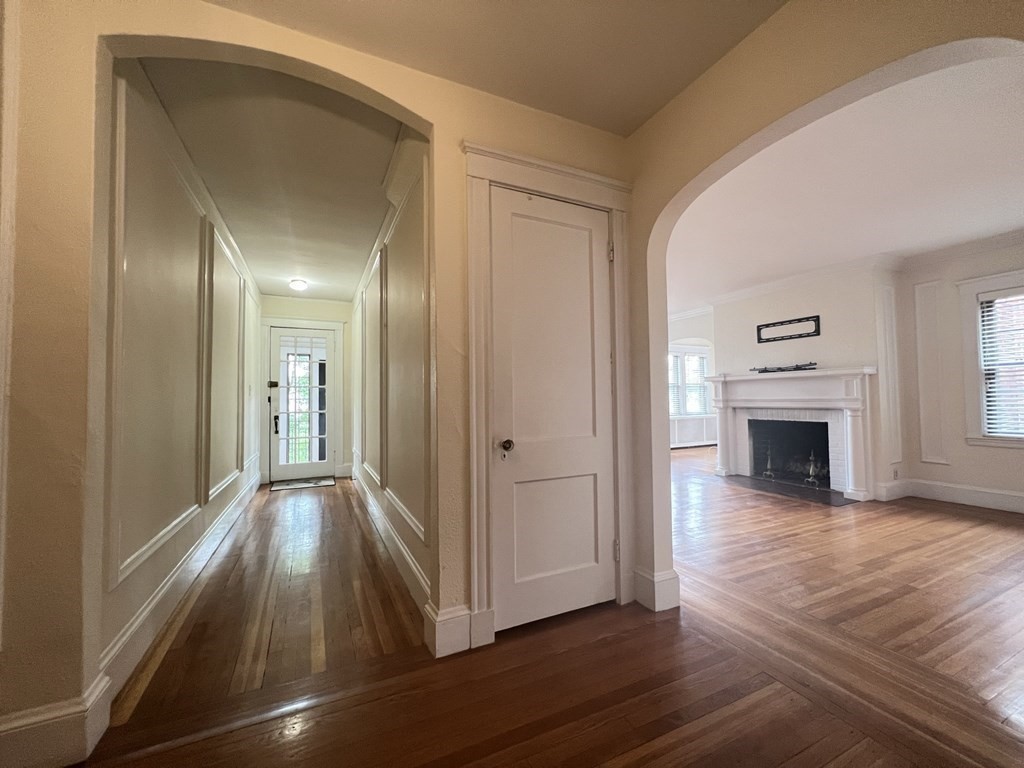 84 Winthrop Road Brookline, MA 02445 - Photo 3 of 42 a view of a livingroom with wooden floor fireplace and window