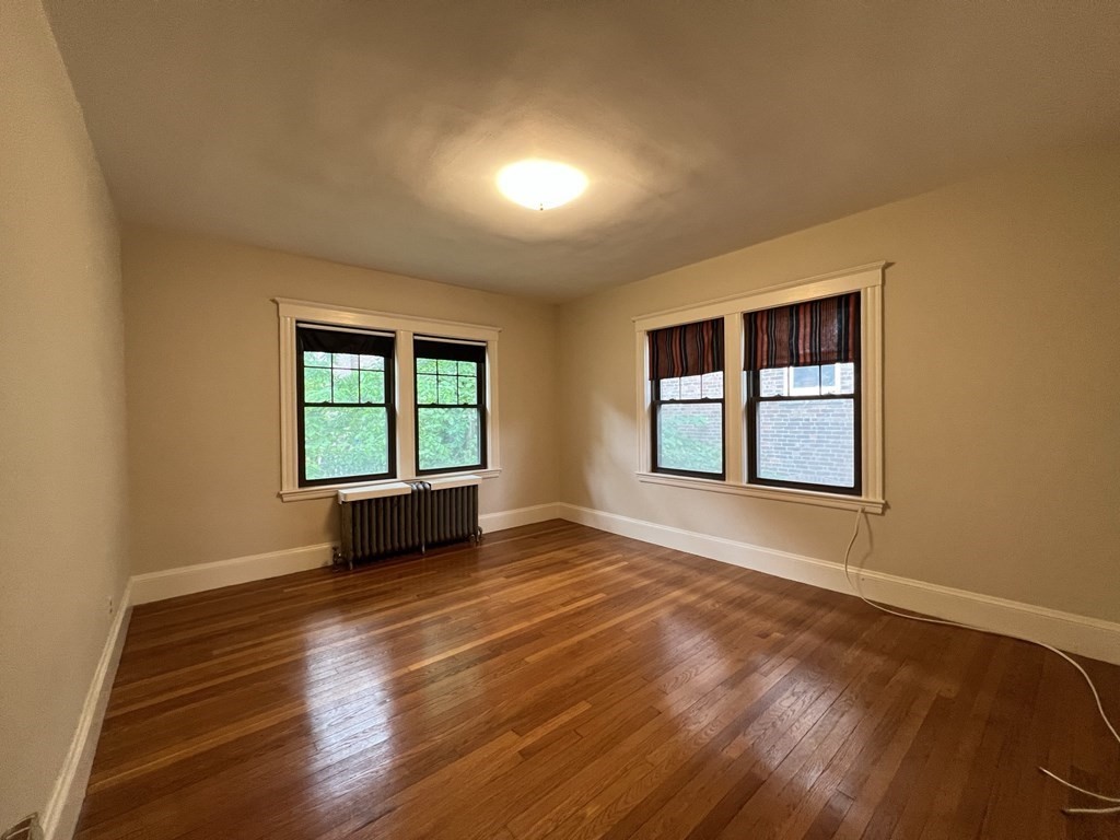 84 Winthrop Road Brookline, MA 02445 - Photo 31 of 42 a view of an empty room with wooden floor and a window