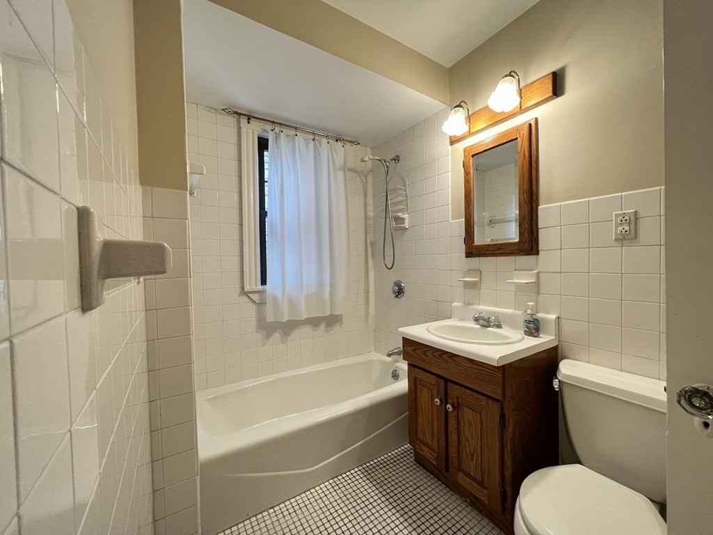 84 Winthrop Road Brookline, MA 02445 - Photo 32 of 42 a bathroom with a tub sink and mirror