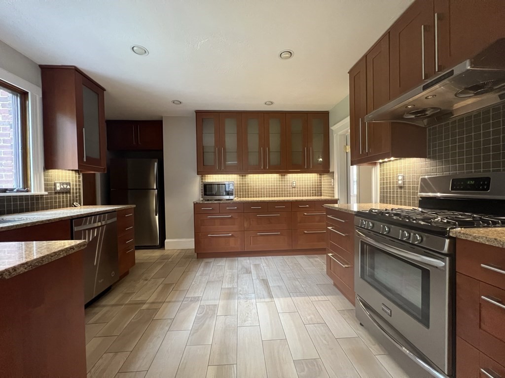 84 Winthrop Road Brookline, MA 02445 - Photo 8 of 42 a kitchen with stainless steel appliances granite countertop a stove a sink and a refrigerator