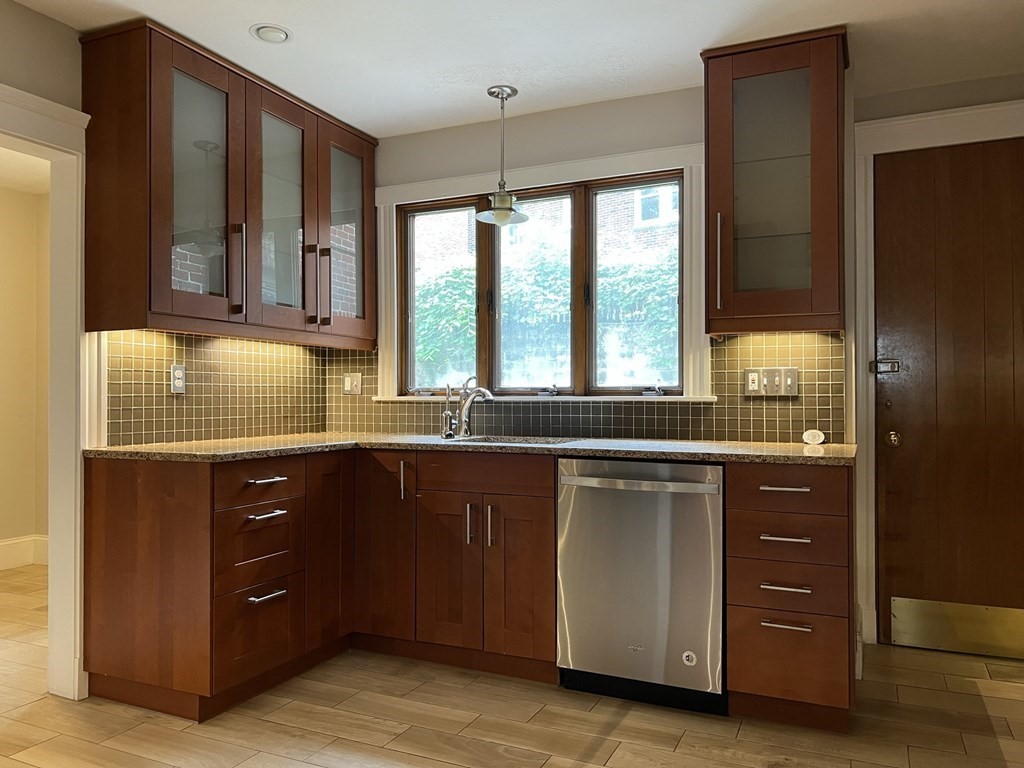 84 Winthrop Road Brookline, MA 02445 - Photo 10 of 42 a kitchen with a sink window and cabinets