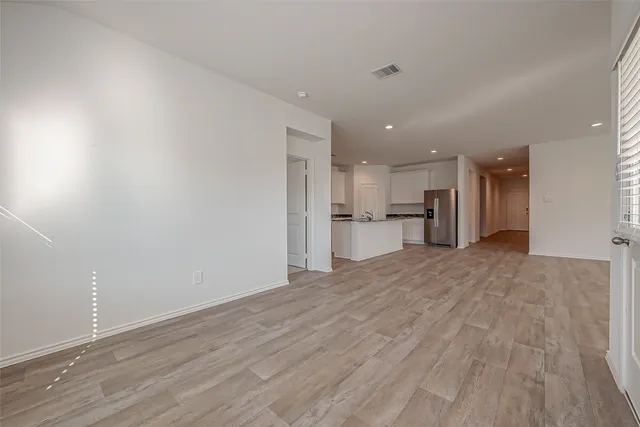 a view of a kitchen with a refrigerator and a stove top oven