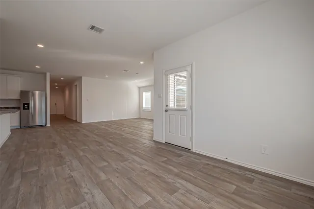 a view of empty room with wooden floor
