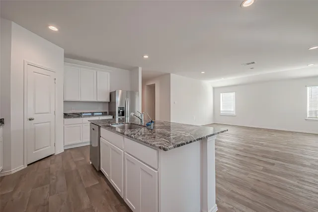 a kitchen with stainless steel appliances granite countertop a sink stove and cabinets