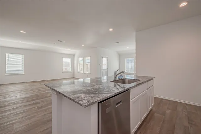 a kitchen with granite countertop kitchen island a sink appliances and a counter space