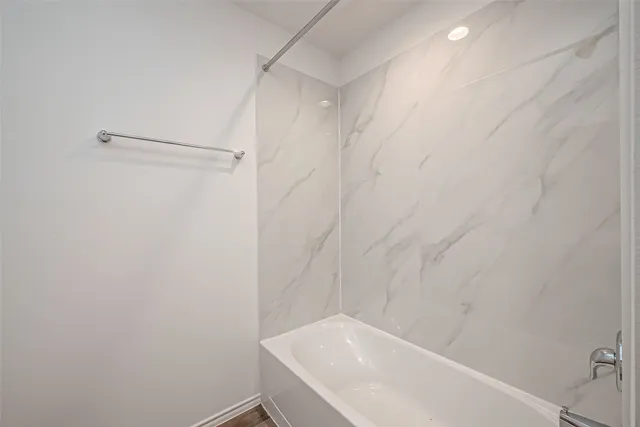 a bathroom with a white bath tub and a shower in it