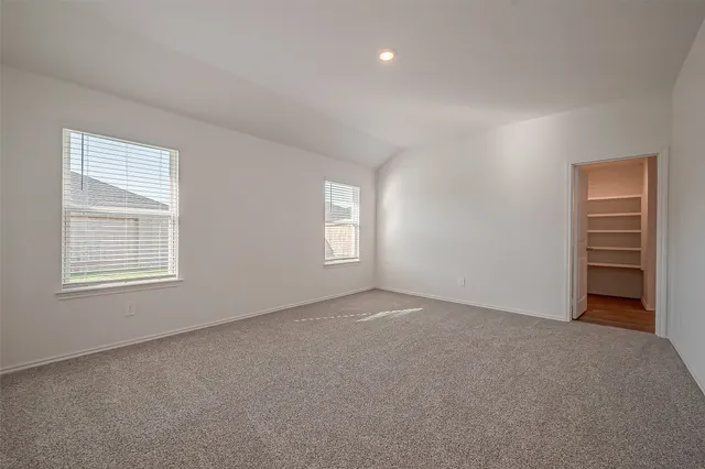 an empty room with windows and closet