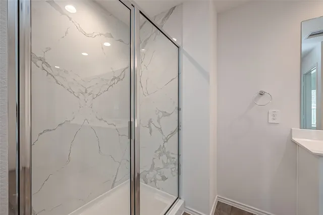 a bathroom with a shower and a glass door
