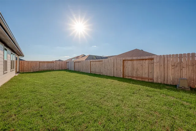 a view of a backyard with wooden fence
