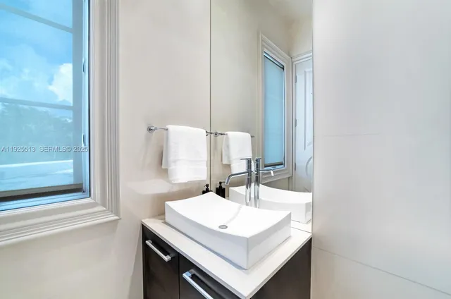 a bathroom with a granite countertop sink and a mirror