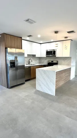 a kitchen with stainless steel appliances granite countertop a sink a stove and a refrigerator