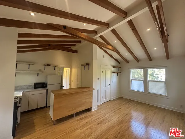 a view of a hallway with wooden floor and windows