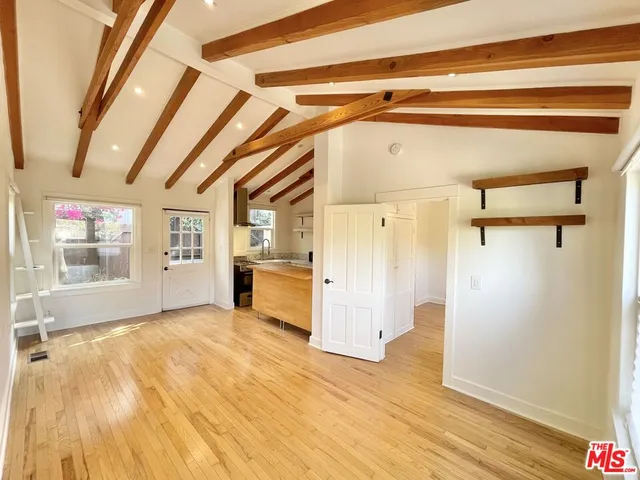 a view of empty room with wooden floor and cabinet