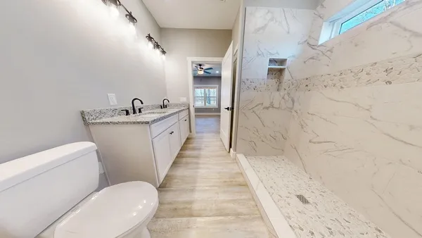 a bathroom with a sink a toilet and shower