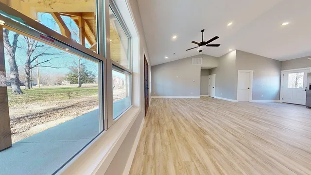 a kitchen with stainless steel appliances granite countertop a refrigerator stove top oven and sink with wooden floor