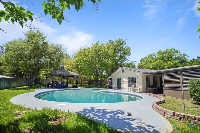 a view of house with swimming pool outdoor seating